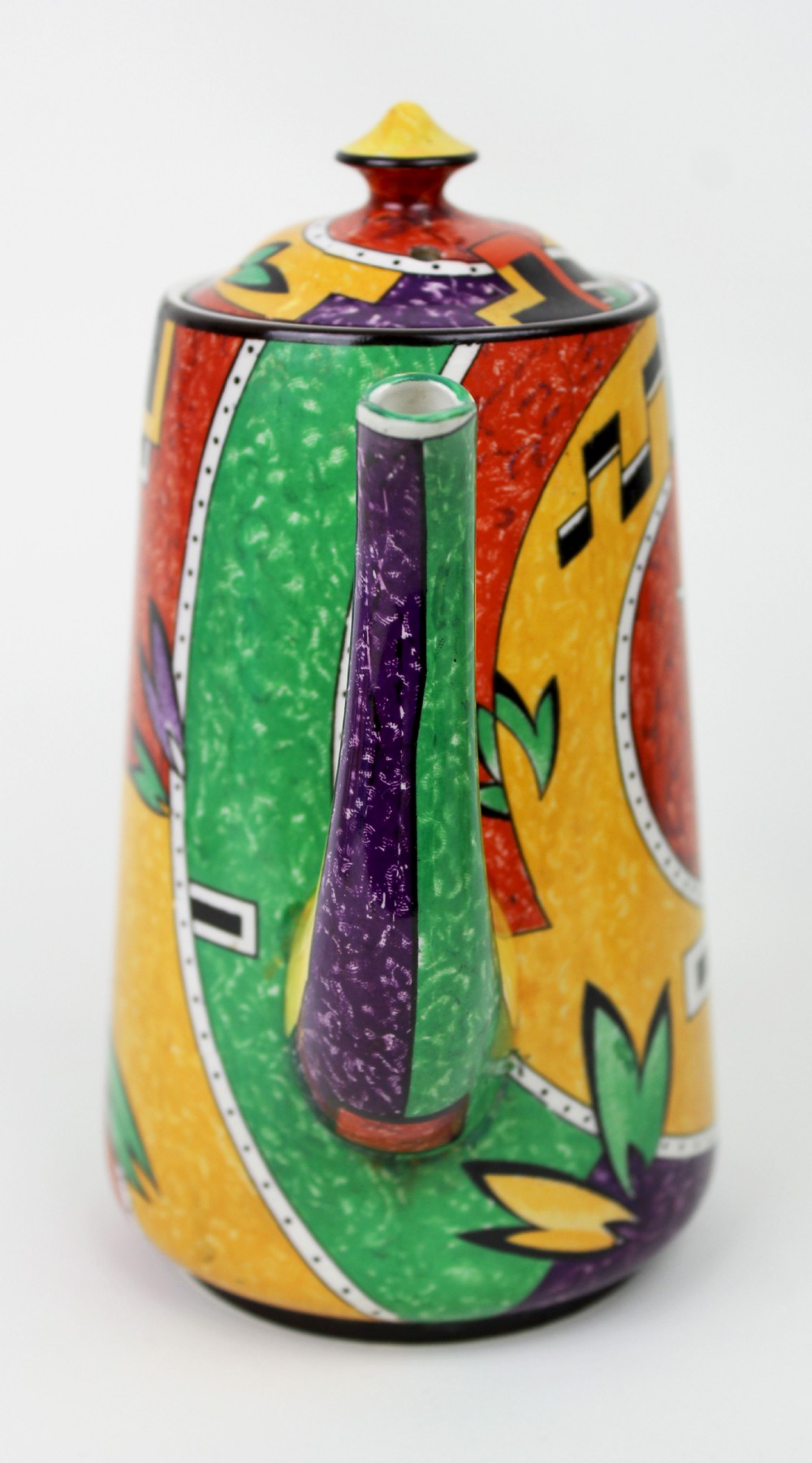 A multi-piece Art Deco ceramic coffee set decorated with vibrant red, yellow, green, and black abstract geometric patterns, comprising a tall coffee pot, creamer, sugar bowl, six demitasse cups, and matching saucers. View VII