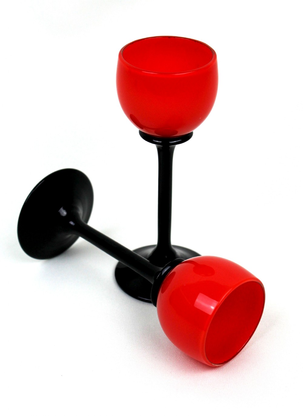 A pair of Art Deco Tango liqueur glasses featuring bright red rounded bowls supported by slender black stems and flat circular black bases. View III