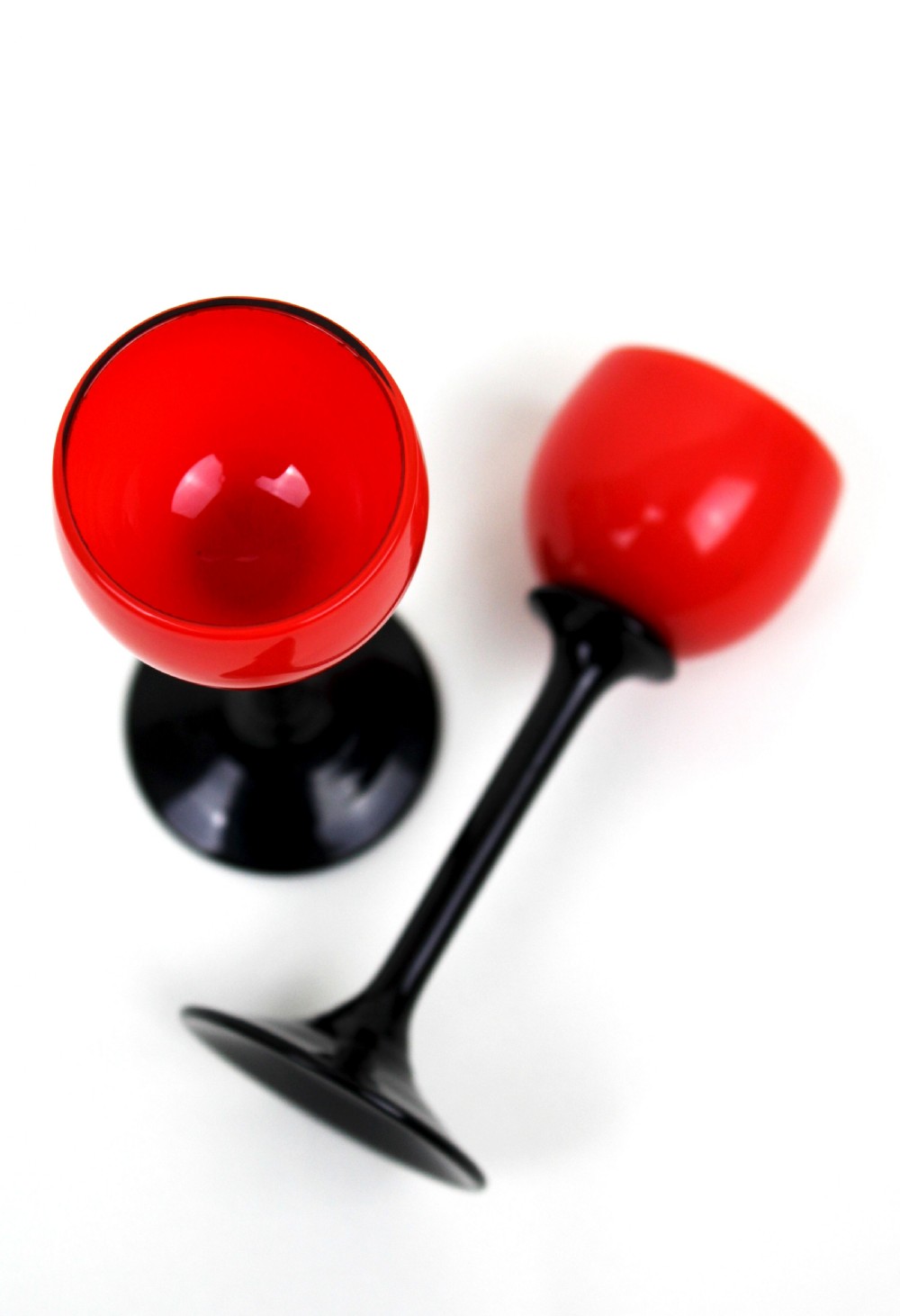 A pair of Art Deco Tango liqueur glasses featuring bright red rounded bowls supported by slender black stems and flat circular black bases. View VI