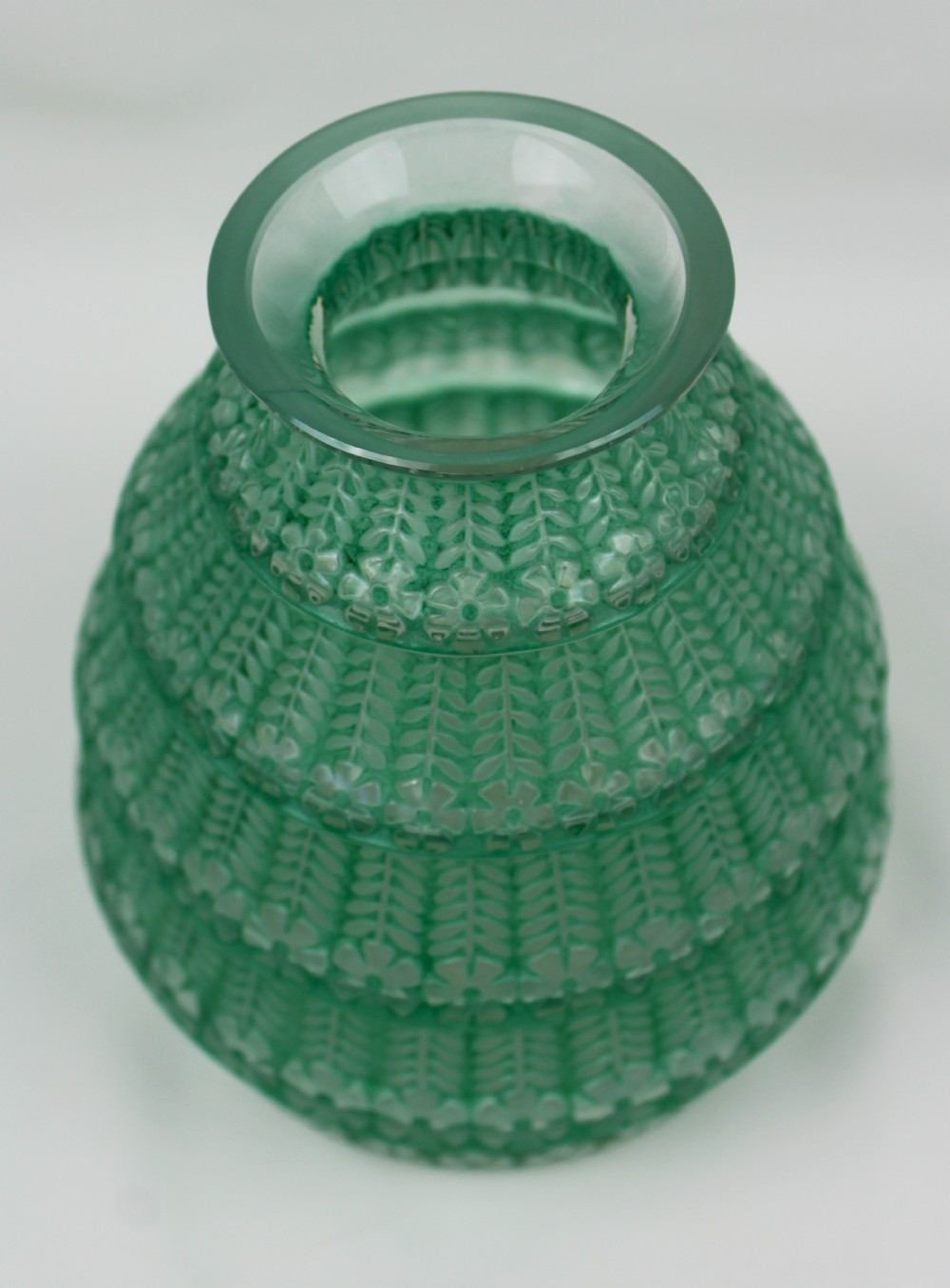 A green frosted glass Art Deco vase featuring tiered conical bands decorated with relief floral and leaf patterns. View III