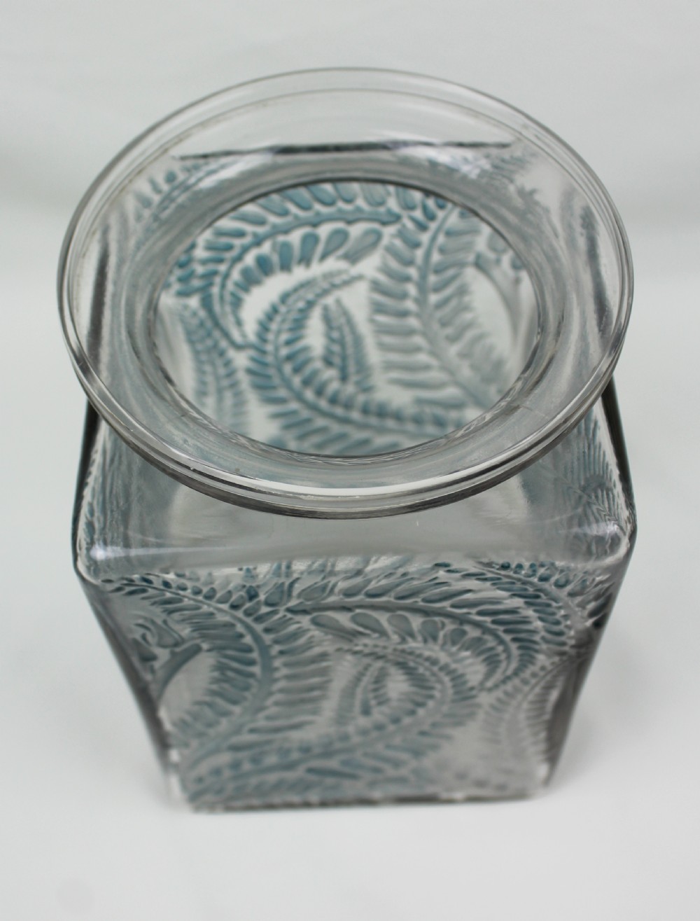 A square Rene Lalique Myrrhis clear glass vase featuring relief-moulded botanical motifs highlighted with blue staining. View IV
