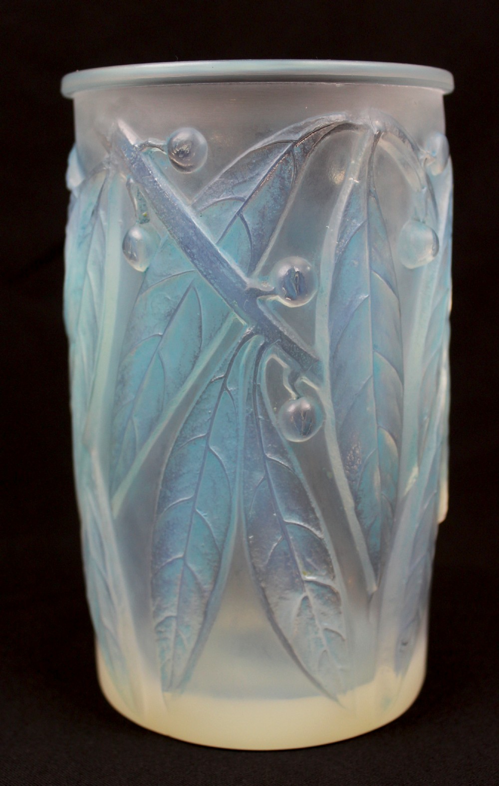 A cylindrical Art Deco opalescent glass vase decorated with relief-moulded laurel leaves and berries tinted in subtle blue.