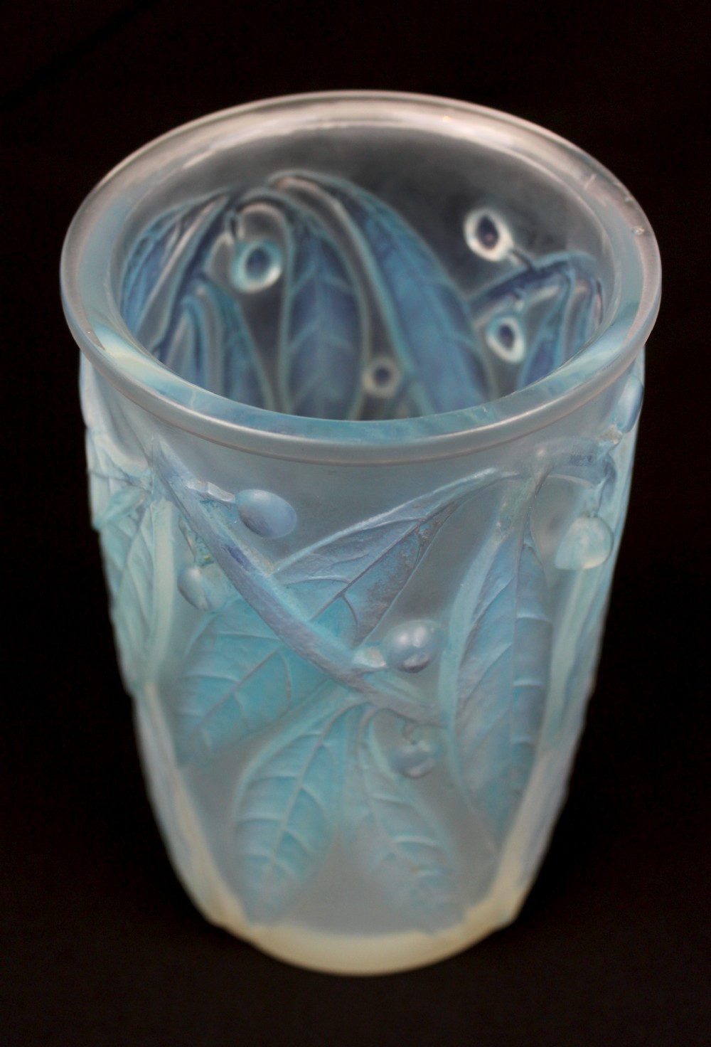 A cylindrical Art Deco opalescent glass vase decorated with relief-moulded laurel leaves and berries tinted in subtle blue. View II