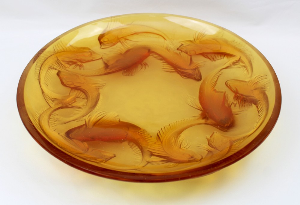 An Art Deco amber glass shallow dish featuring a relief motif of swimming fish radiating around the centre. View II