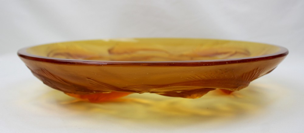 An Art Deco amber glass shallow dish featuring a relief motif of swimming fish radiating around the centre. View III