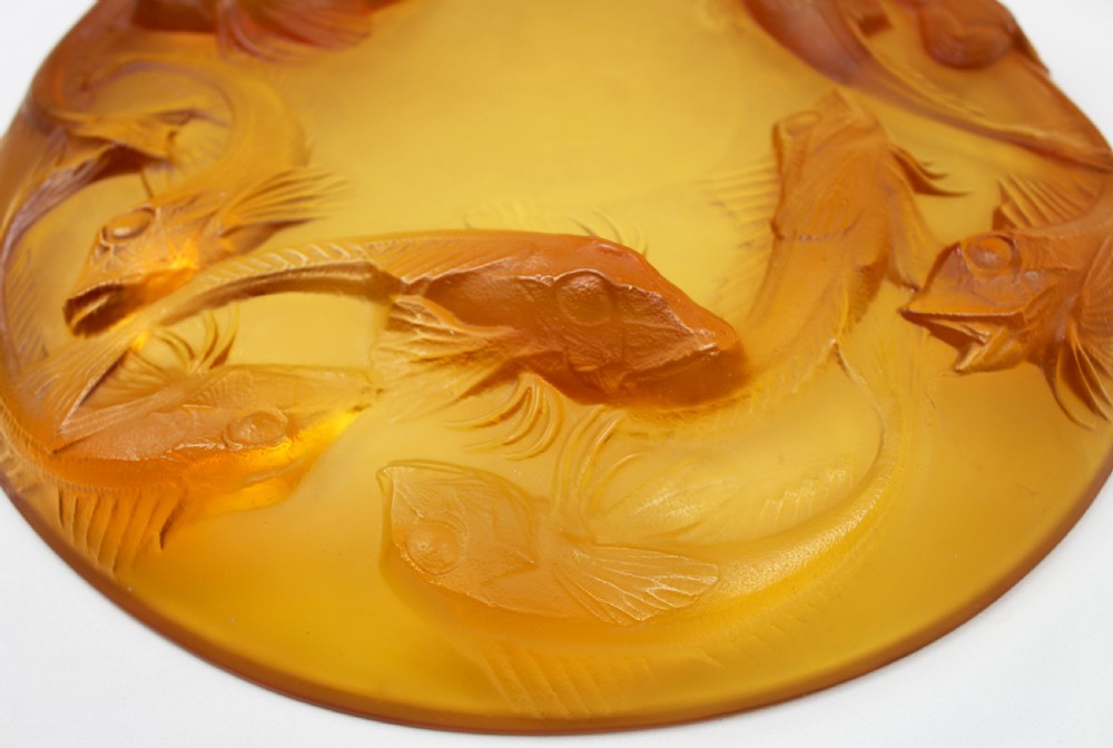 An Art Deco amber glass shallow dish featuring a relief motif of swimming fish radiating around the centre. View V