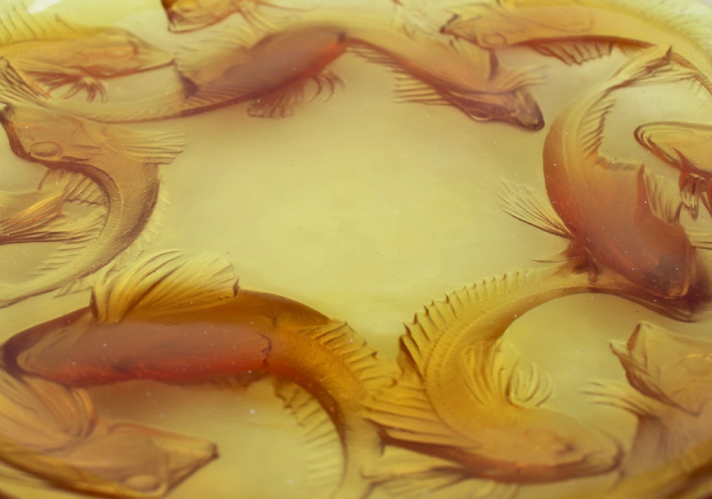 An Art Deco amber glass shallow dish featuring a relief motif of swimming fish radiating around the centre. View VI
