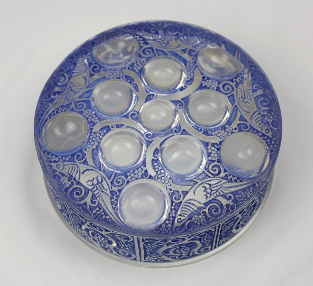 A circular Art Deco blue-stained glass powder box featuring moulded relief patterns of birds, grapevines, and polished glass cabochons. View II