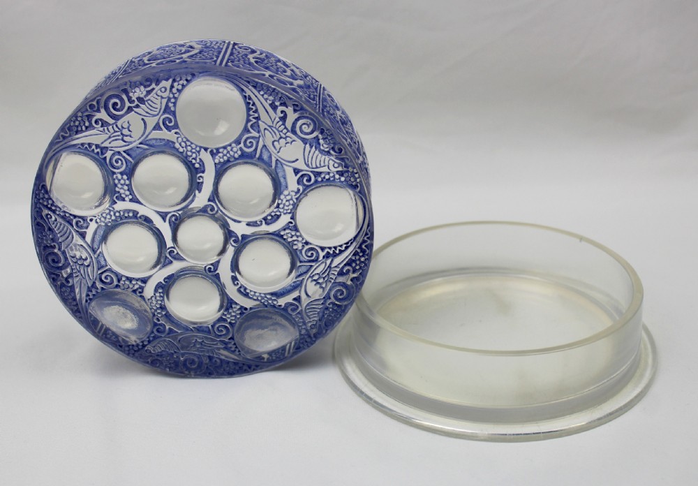 A circular Art Deco blue-stained glass powder box featuring moulded relief patterns of birds, grapevines, and polished glass cabochons. View V