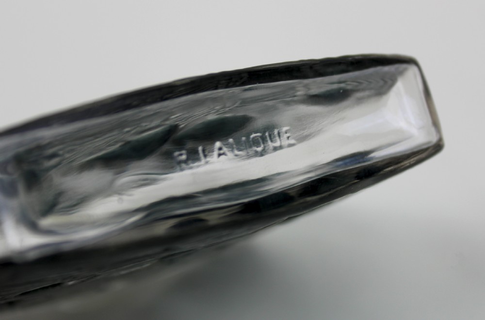 A rectangular frosted glass perfume bottle featuring relief carvings of flying swallows and a matching flat stopper. View V
