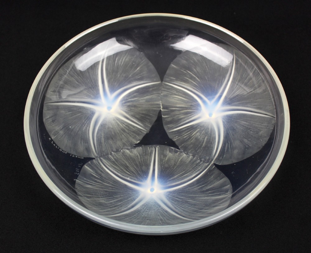 A circular Rene Lalique opalescent glass bowl featuring three relief-moulded morning glory flowers whose stems extend to form feet on the underside.