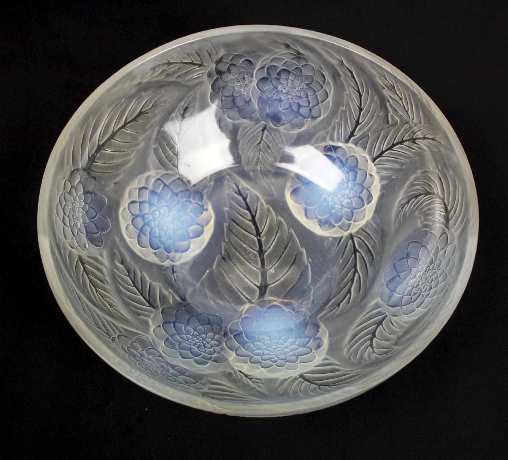 An Art Deco opalescent glass circular bowl featuring a moulded relief design of dahlia flower heads and leaves with subtle blue highlights.