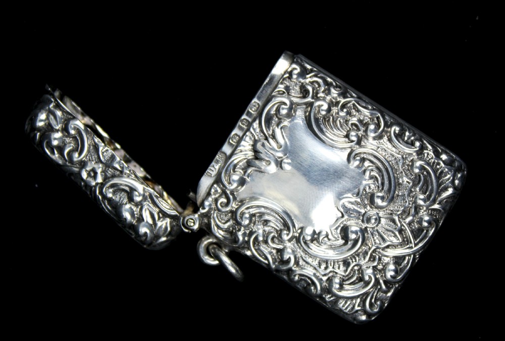 An ornate rectangular sterling silver Vesta case featuring embossed scrollwork and a central engraved cartouche with initials. View III