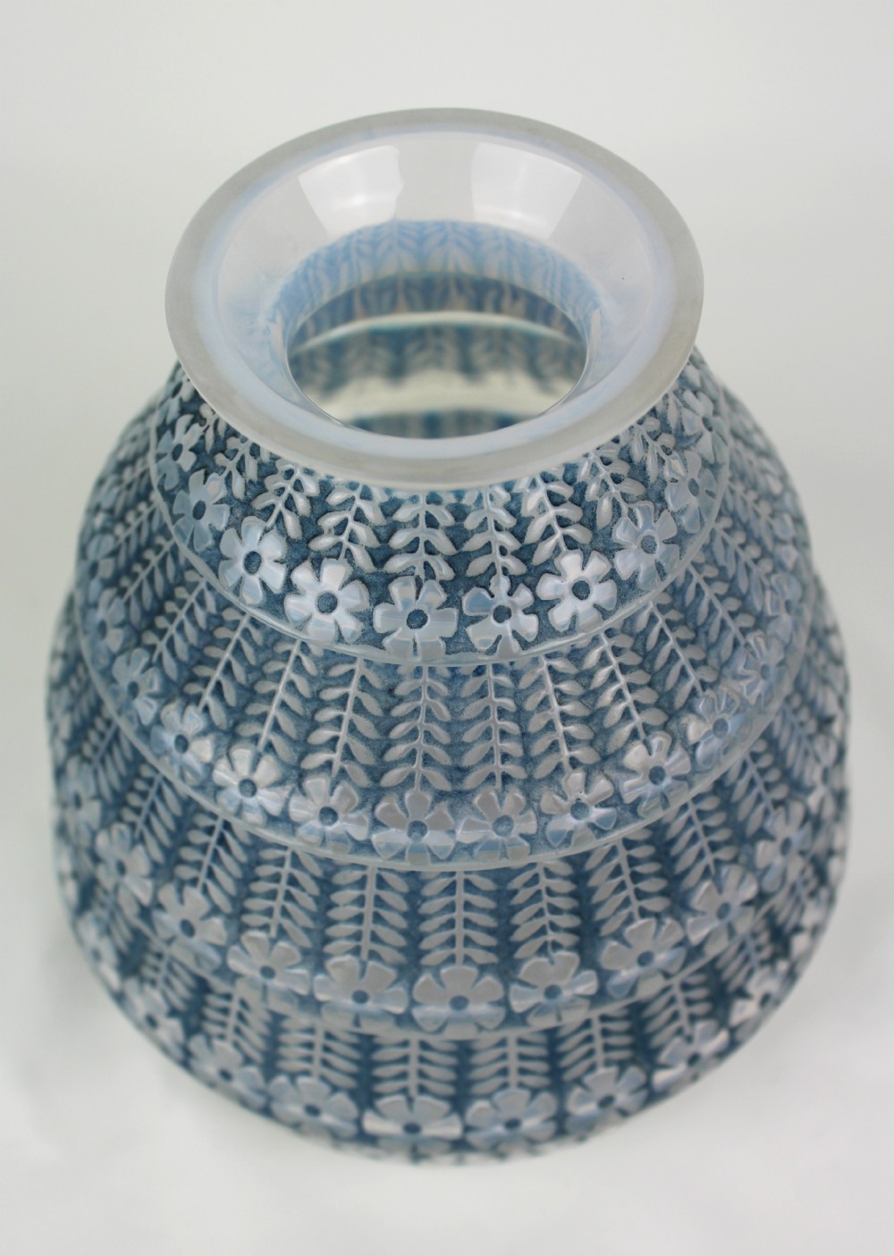 A conical frosted glass vase featuring stepped tiers with relief-moulded floral and leaf motifs highlighted in blue staining. View III