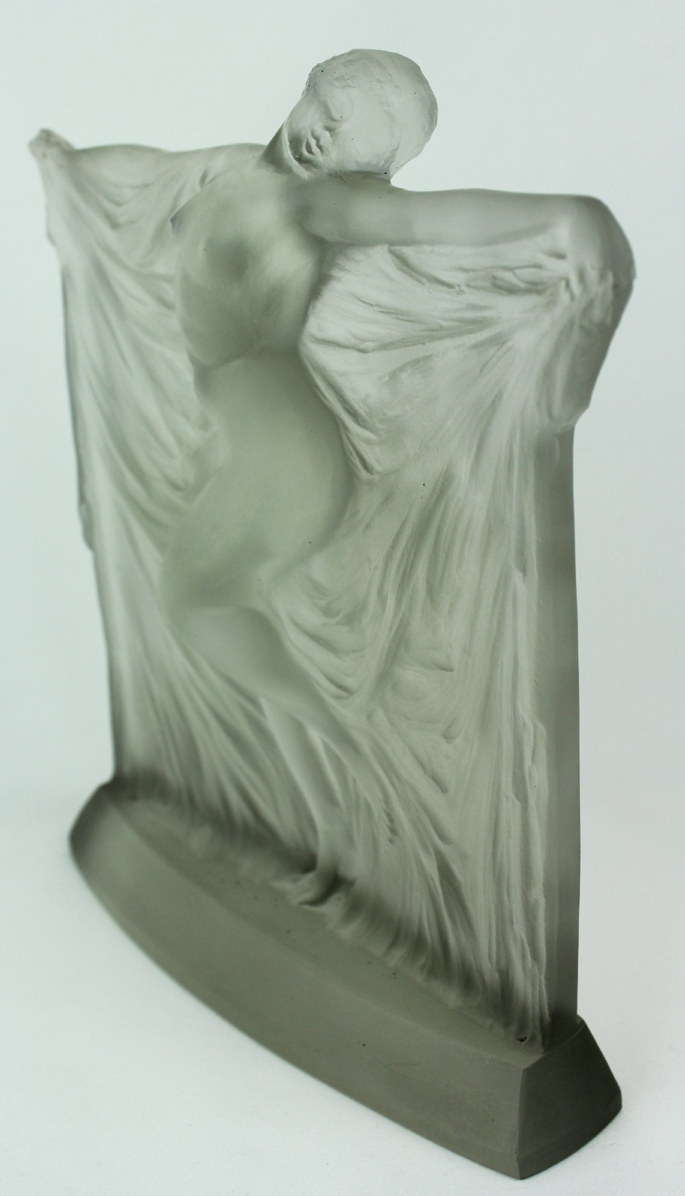 A frosted glass Art Deco statuette depicting a female figure with outstretched arms holding flowing drapery on a curved base. View V
