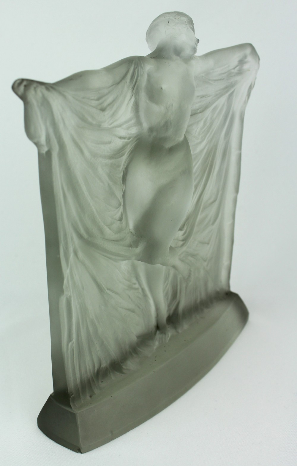A frosted glass Art Deco statuette depicting a female figure with outstretched arms holding flowing drapery on a curved base. View VI