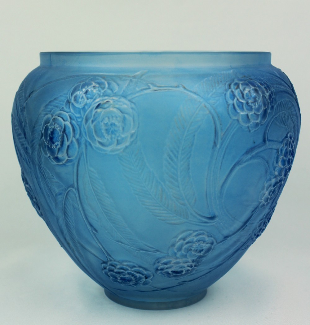 A spherical frosted blue glass vase decorated with moulded floral and leaf relief patterns across the exterior surface.