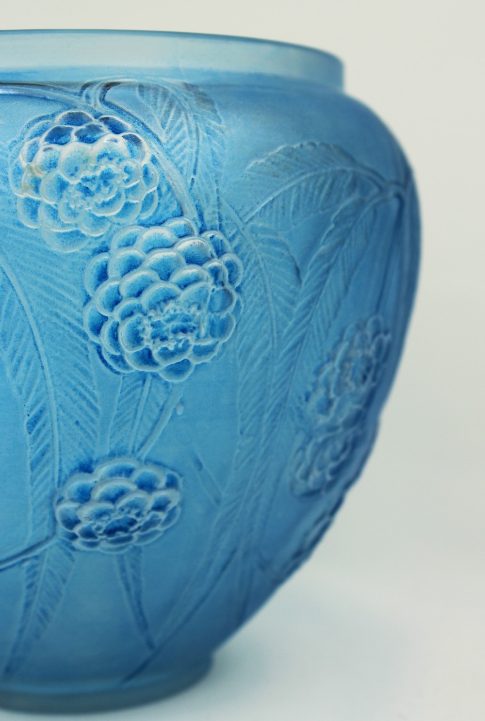 A spherical frosted blue glass vase decorated with moulded floral and leaf relief patterns across the exterior surface. View III