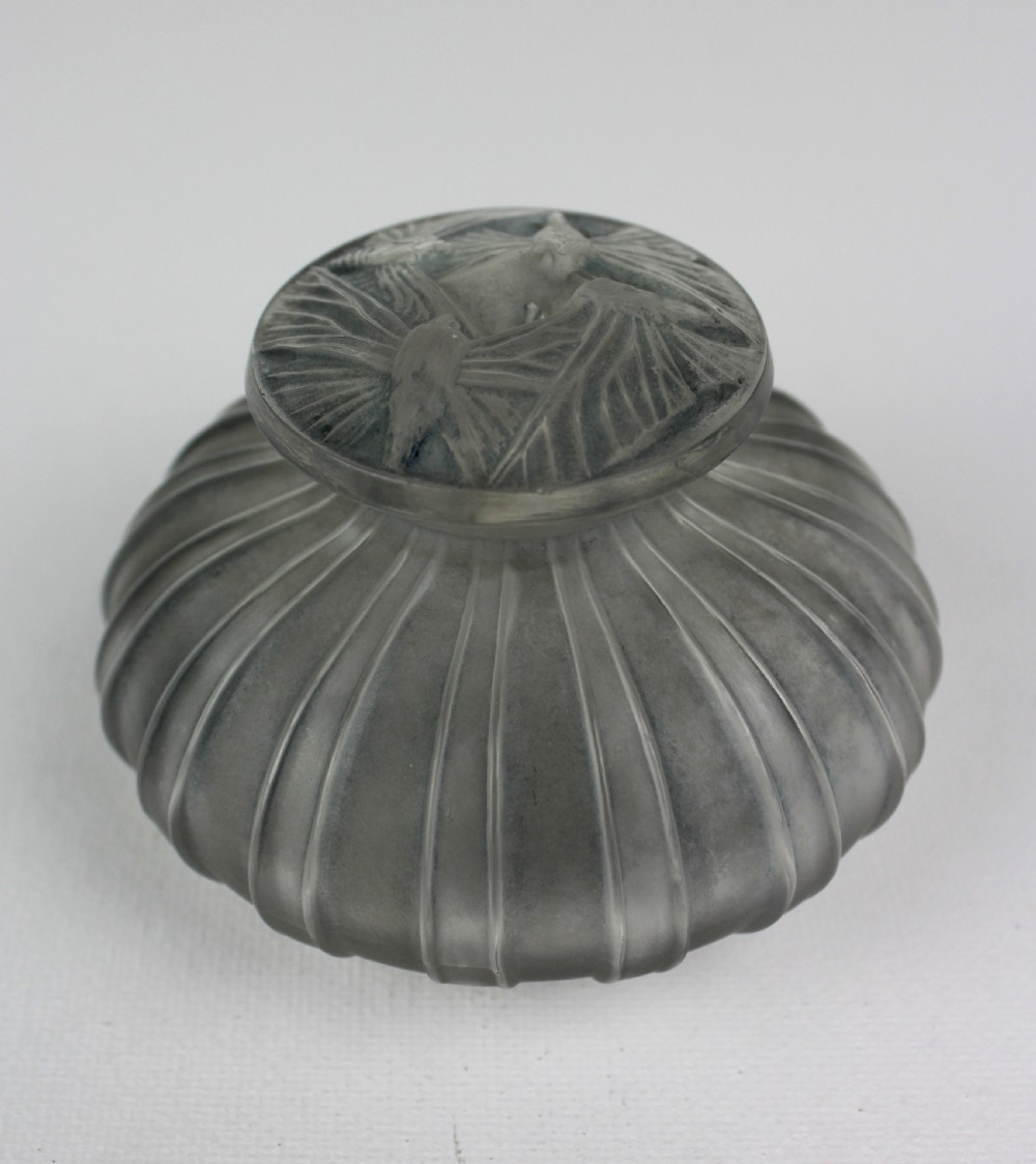 A ribbed frosted grey glass scent bottle featuring a round flat stopper moulded with butterfly relief details.
