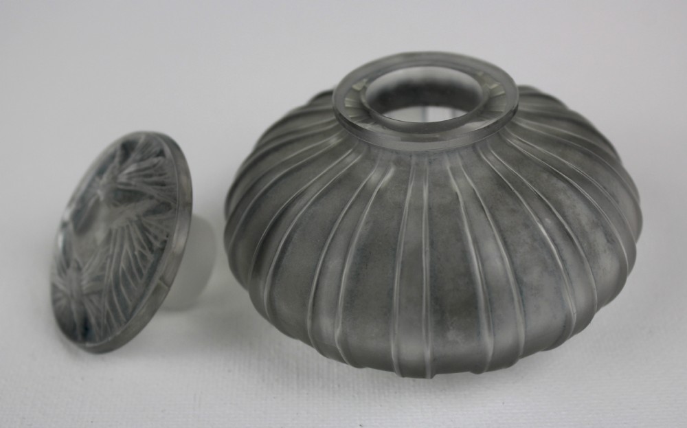 A ribbed frosted grey glass scent bottle featuring a round flat stopper moulded with butterfly relief details. View IV