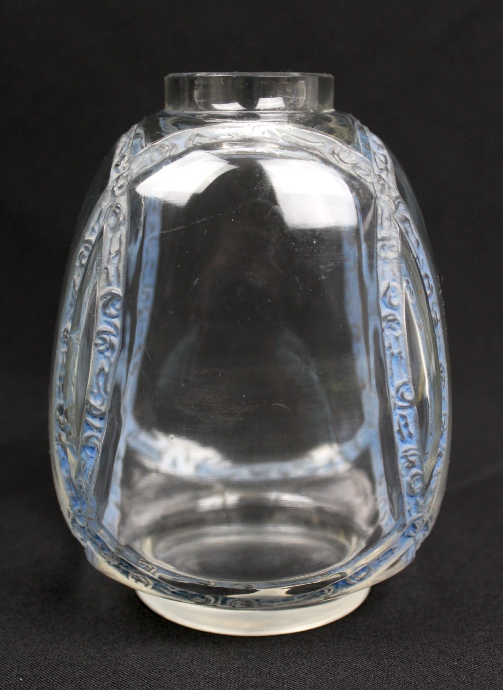 A clear moulded glass vase featuring intersecting blue patinated floral garland bands around an ovoid body. View II