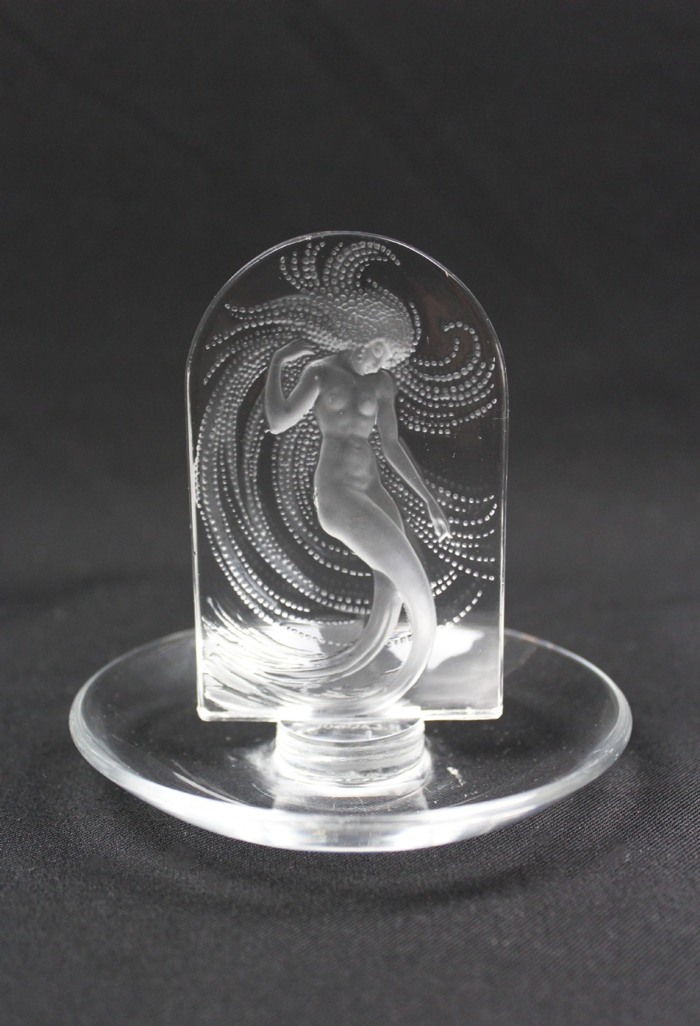 A clear glass pin dish featuring an upright arched centrepiece with a frosted glass relief depiction of a nymph surrounded by swirling beaded patterns. View III