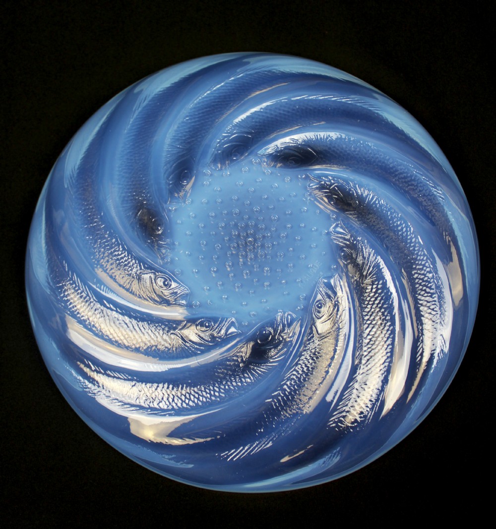 A circular Art Deco opalescent blue glass plate decorated with a swirling relief design of fish radiating from a central field of small raised bubbles. View IV