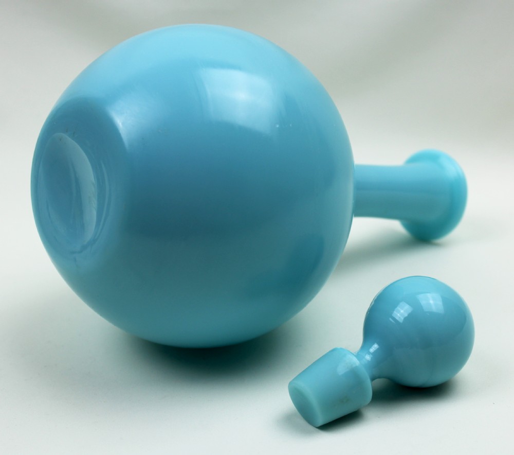 A turquoise blue opaline glass decanter featuring a spherical body, a long slender neck, a flanged rim, and a matching ball stopper. View IV