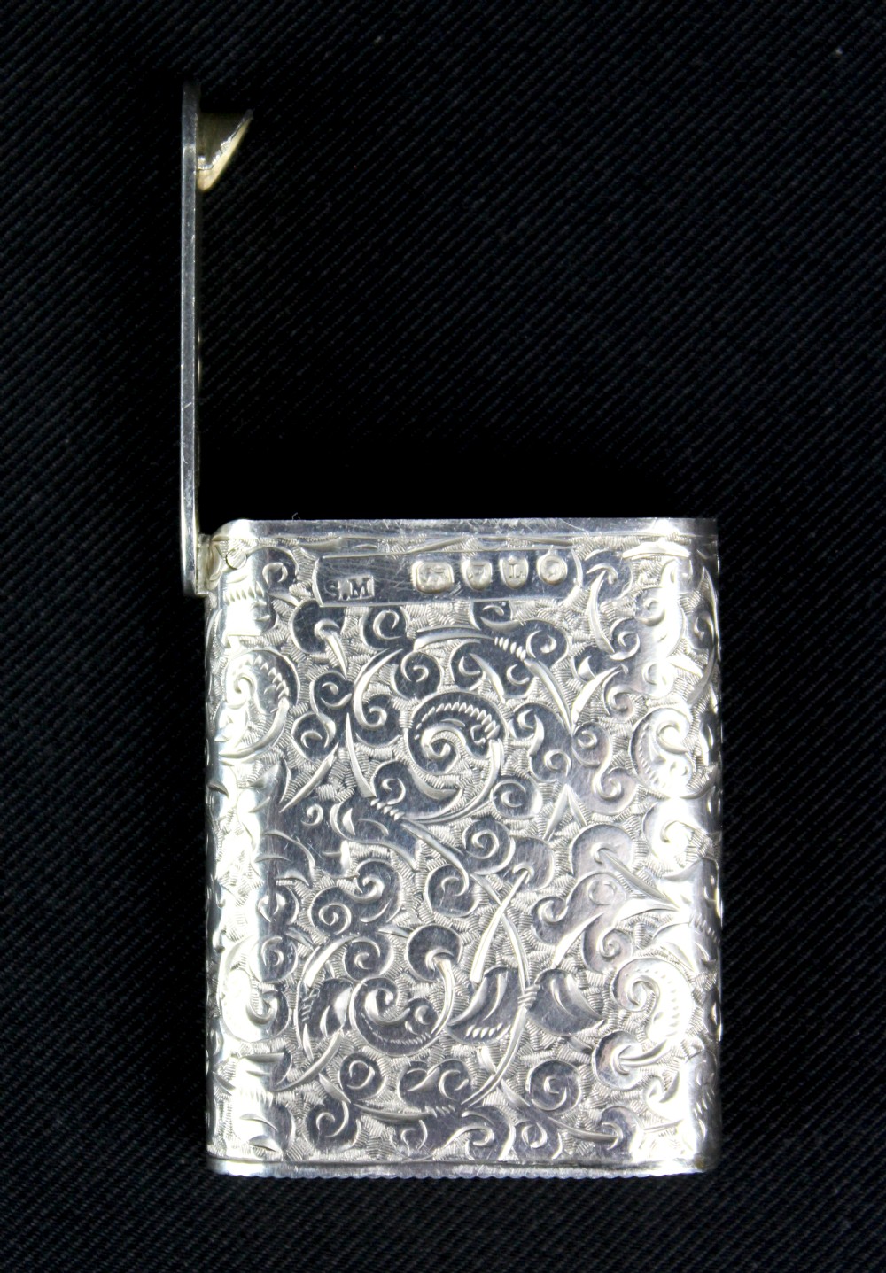 A rectangular sterling silver vesta case featuring hand-engraved foliate scrollwork and an unengraved circular central cartouche. View IV