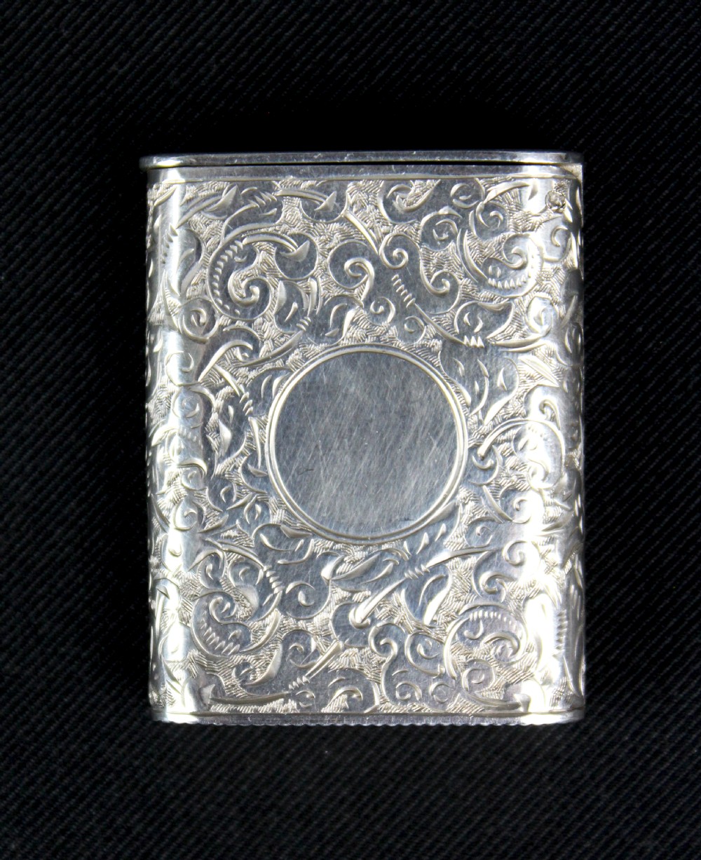 A rectangular sterling silver vesta case featuring hand-engraved foliate scrollwork and an unengraved circular central cartouche. View VI