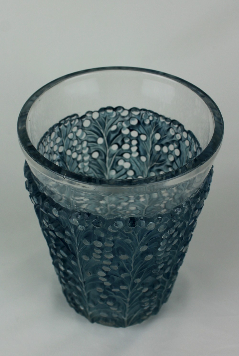 An Art Deco Rene Lalique Saint Tropez vase in clear and frosted blue-stained glass featuring a raised foliage and berry relief pattern. View II