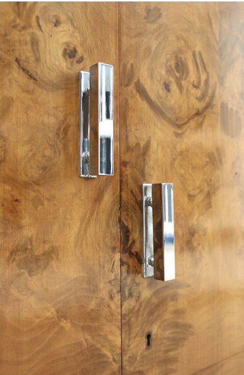 fig 1. An Art Deco burr walnut tallboy featuring chamfered corners, highly figured book-matched veneer, two long doors, and vertically aligned central handles.