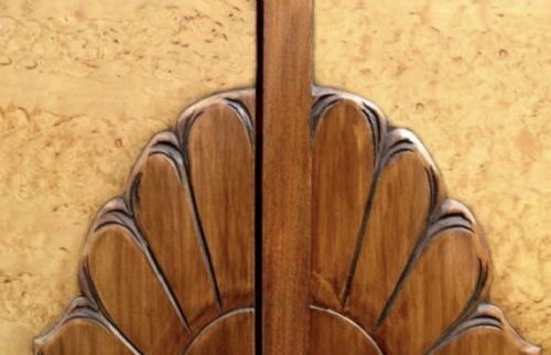 fig 1. An Art Deco double wardrobe crafted from blonde birds eye maple veneer with darker wood border details and a carved central escutcheon.