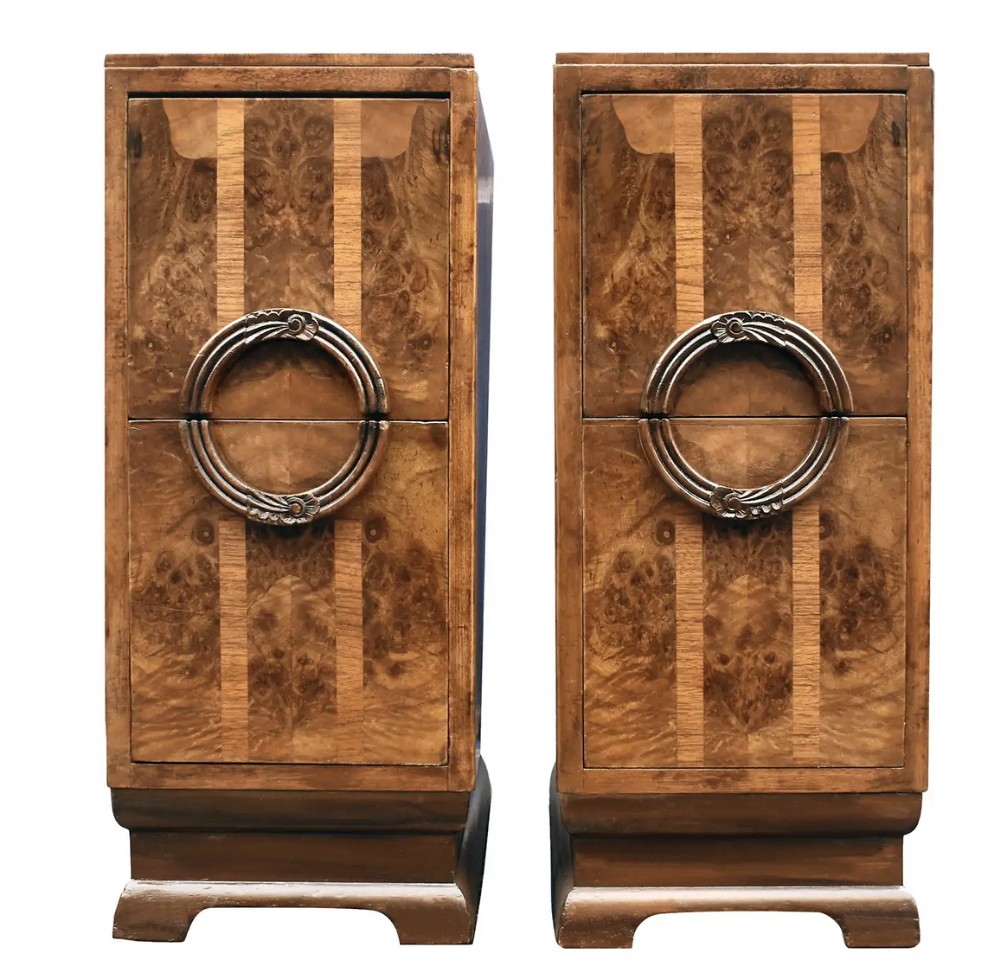 A pair of tall English 1930s Art Deco figured walnut bedside cabinets with vertical stripe veneer details and split circular handles.