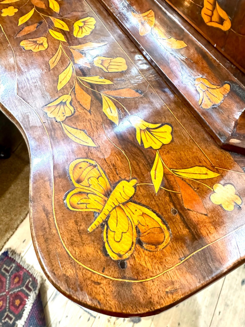 An antique Dutch walnut display cabinet featuring intricate floral wood marquetry, an arched glazed top, and a base with four drawers. View III