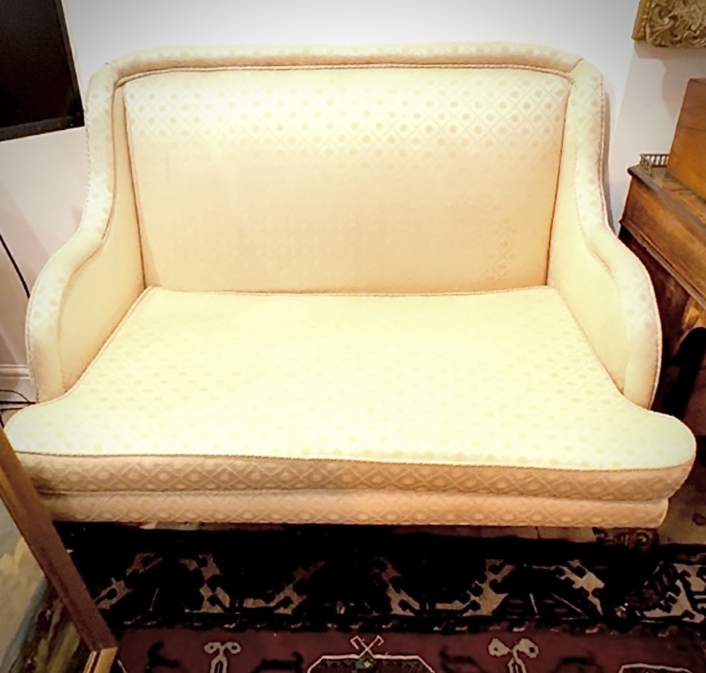 An Edwardian two-seater settee upholstered in cream geometric patterned fabric with piping trim and raised on dark carved mahogany cabriole legs. View II