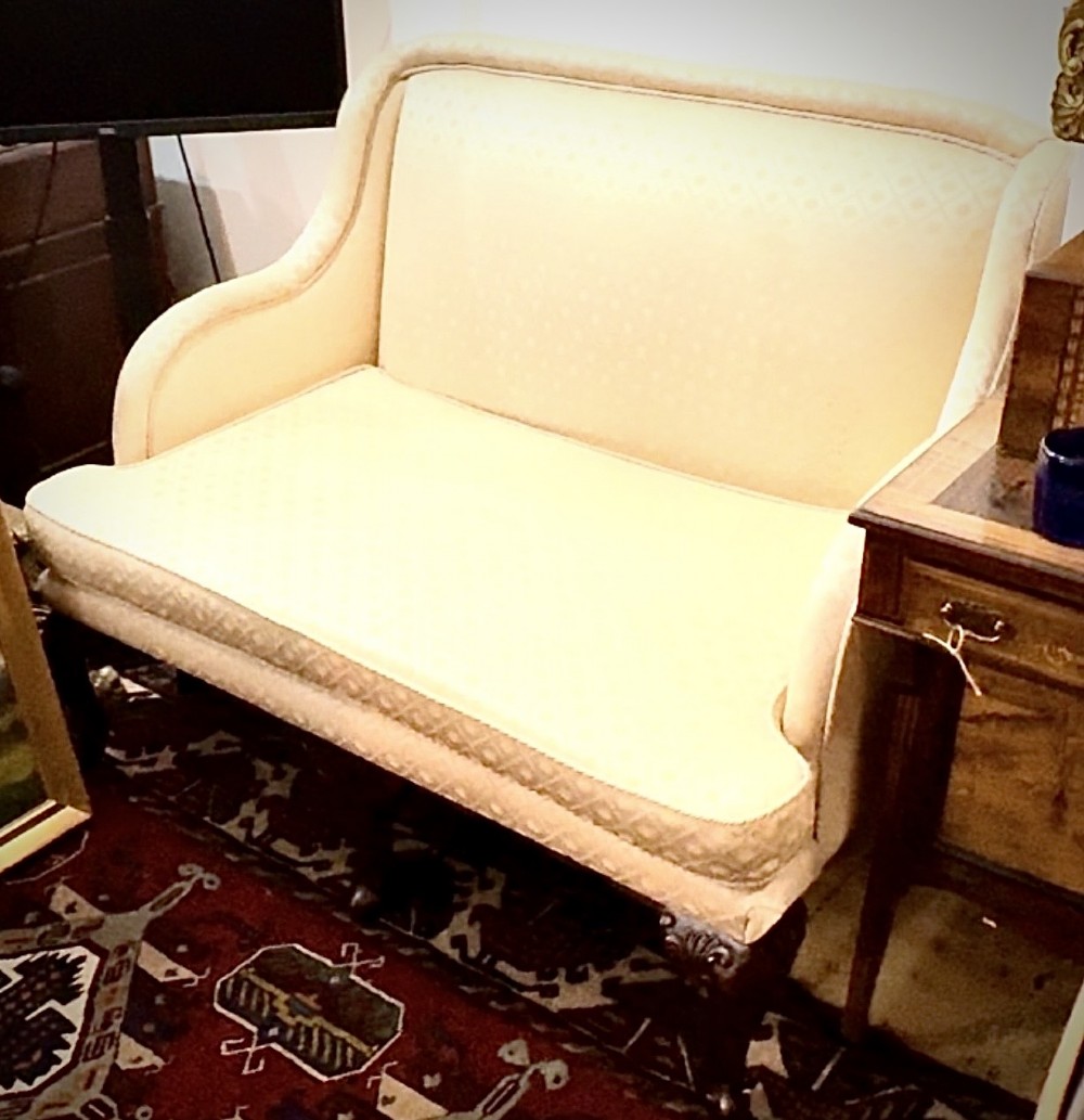 An Edwardian two-seater settee upholstered in cream geometric patterned fabric with piping trim and raised on dark carved mahogany cabriole legs. View III