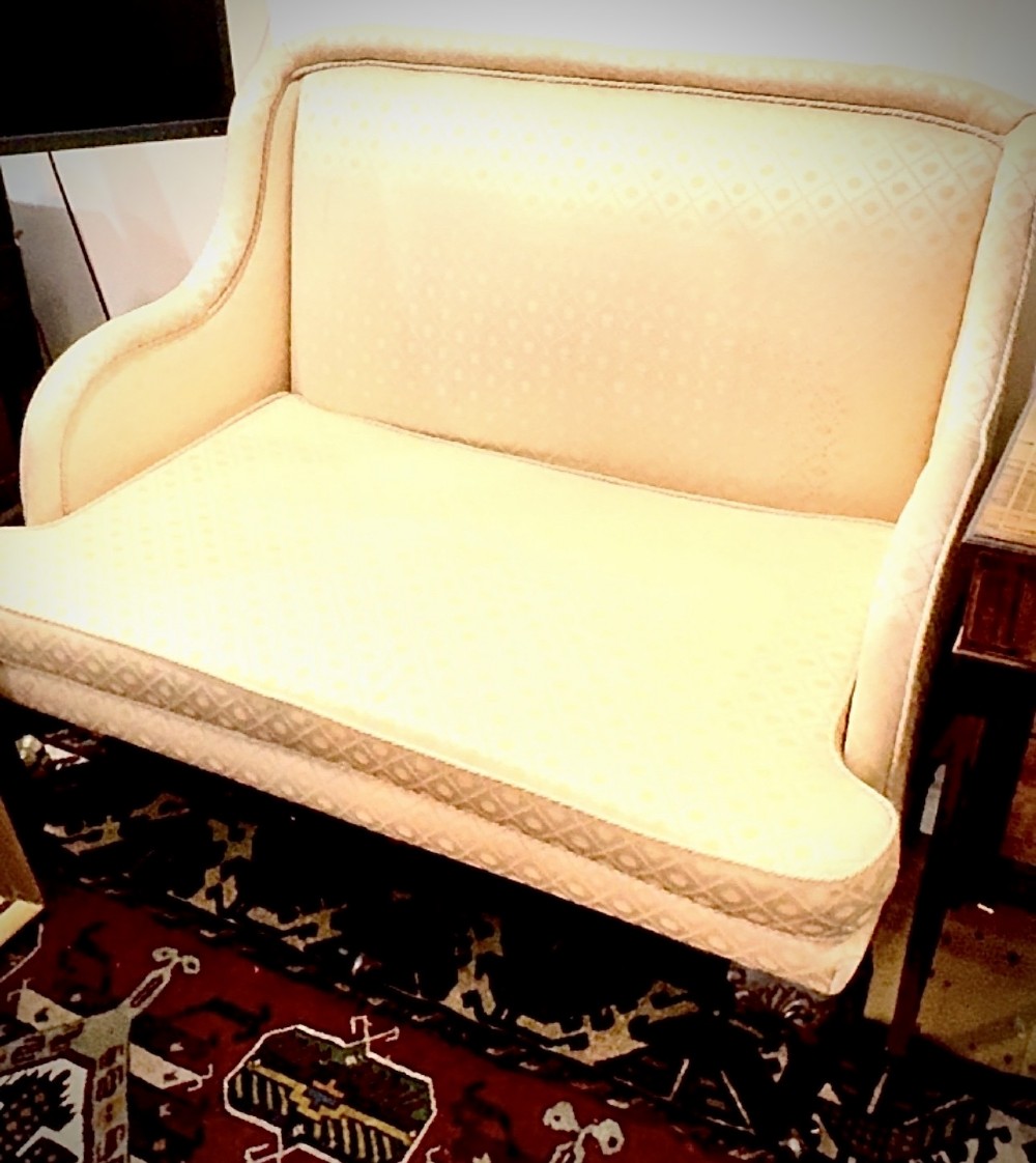 An Edwardian two-seater settee upholstered in cream geometric patterned fabric with piping trim and raised on dark carved mahogany cabriole legs. View IV