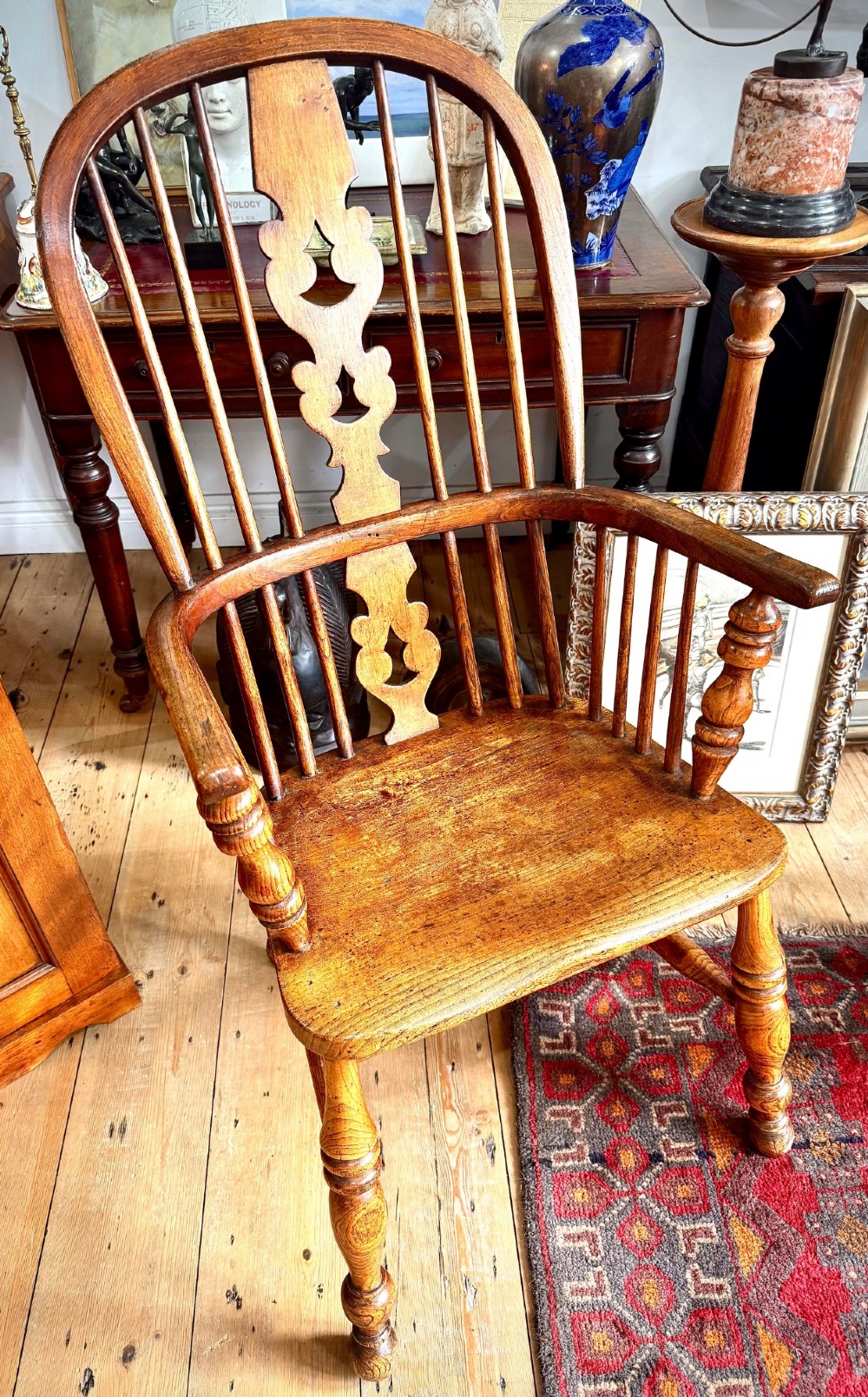 A 19th-century high-back Windsor armchair featuring a steam-bent hoop back, pierced central splat, shaped elm seat, and turned wooden legs. View II