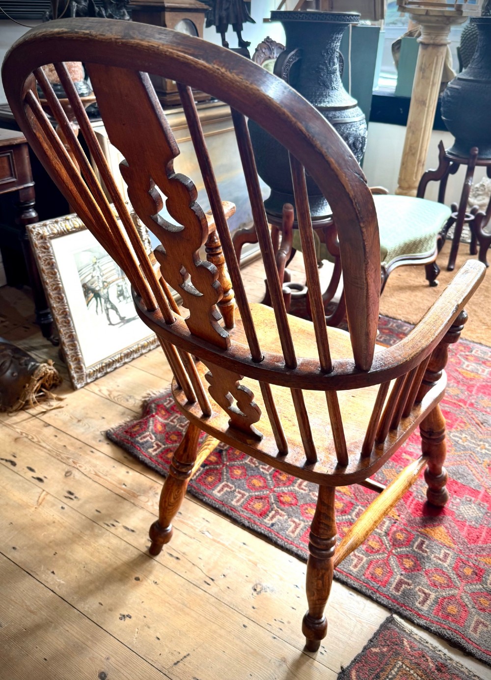 A 19th-century high-back Windsor armchair featuring a steam-bent hoop back, pierced central splat, shaped elm seat, and turned wooden legs. View III