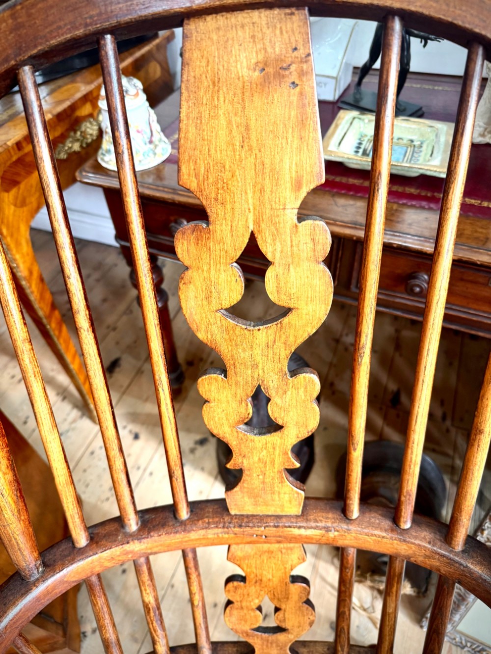A 19th-century high-back Windsor armchair featuring a steam-bent hoop back, pierced central splat, shaped elm seat, and turned wooden legs. View V