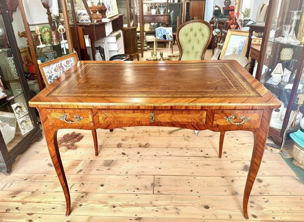 A French Louis XV style kingwood bureau desk featuring a gilt-tooled leather writing insert, parquetry veneer, drawer compartments with brass handles, and sweeping cabriole legs. View III