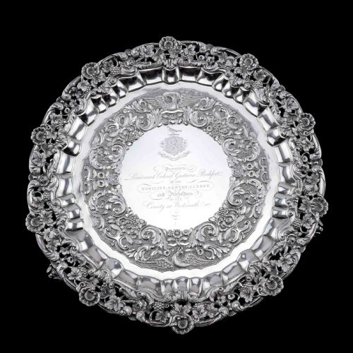fig 6. A circular Georgian sterling silver salver featuring an intricately detailed cast floral border and central inscription engraving.