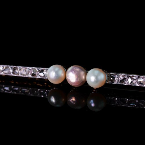 fig 6. An antique platinum and gold linear bar brooch set with diamonds and three central pearls, featuring a soft pink pearl in the centre.