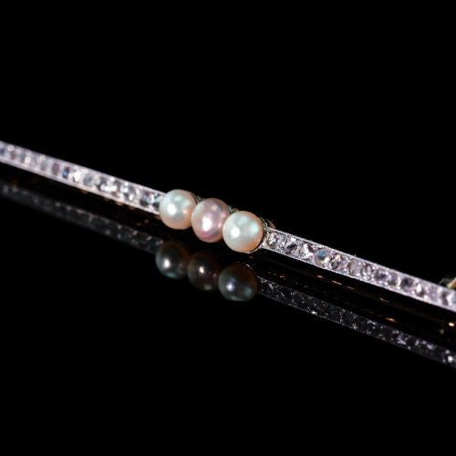fig 7. An antique platinum and gold linear bar brooch set with diamonds and three central pearls, featuring a soft pink pearl in the centre.