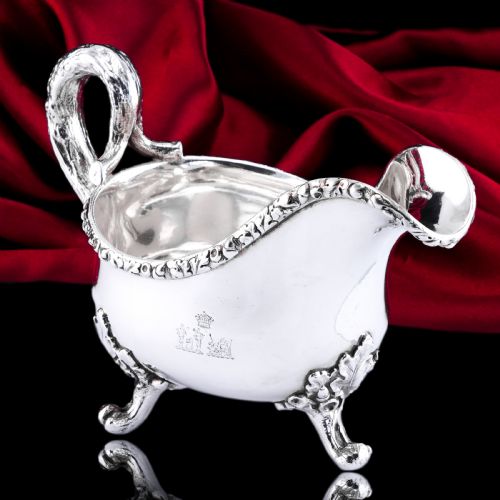 fig 2. A Victorian sterling silver sauce boat featuring an organic twig handle, acorn feet, and engraved crest detailing.