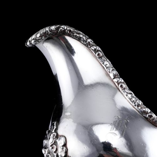 fig 3. A Victorian sterling silver sauce boat featuring an organic twig handle, acorn feet, and engraved crest detailing.