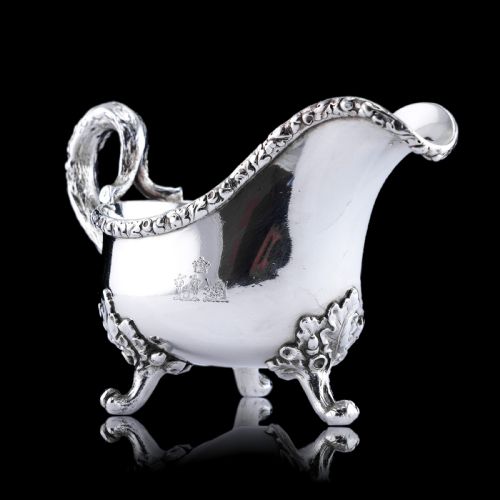 fig 5. A Victorian sterling silver sauce boat featuring an organic twig handle, acorn feet, and engraved crest detailing.
