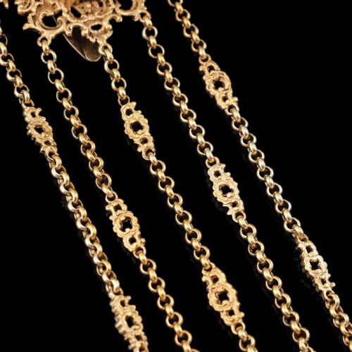 fig 1. An ornate Victorian silver-gilt chatelaine featuring five hanging chains with swivel clips and a rococo plaque detailed with a central cherub motif.