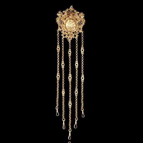 fig 3. An ornate Victorian silver-gilt chatelaine featuring five hanging chains with swivel clips and a rococo plaque detailed with a central cherub motif.